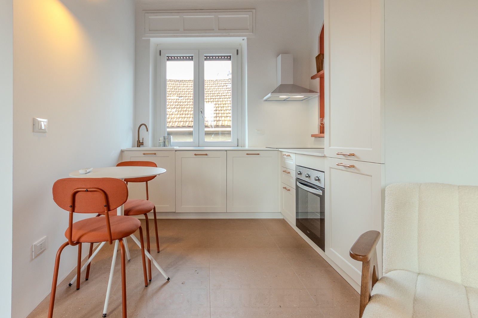 Cucina completa con ante bianche, forno, piano a induzione e cappa — appartamento a Monza